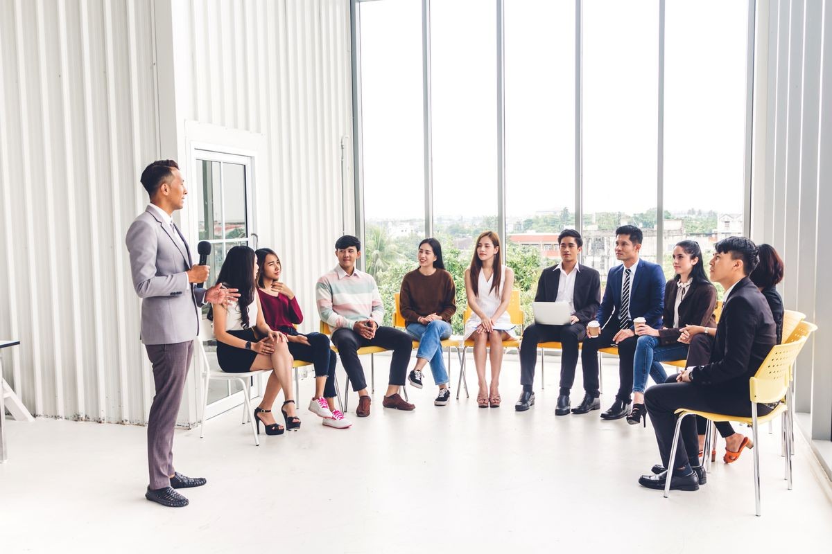 Businessman standing in front of group of people in consulting meeting conference seminar at hall or seminar room.presentation and coaching concept