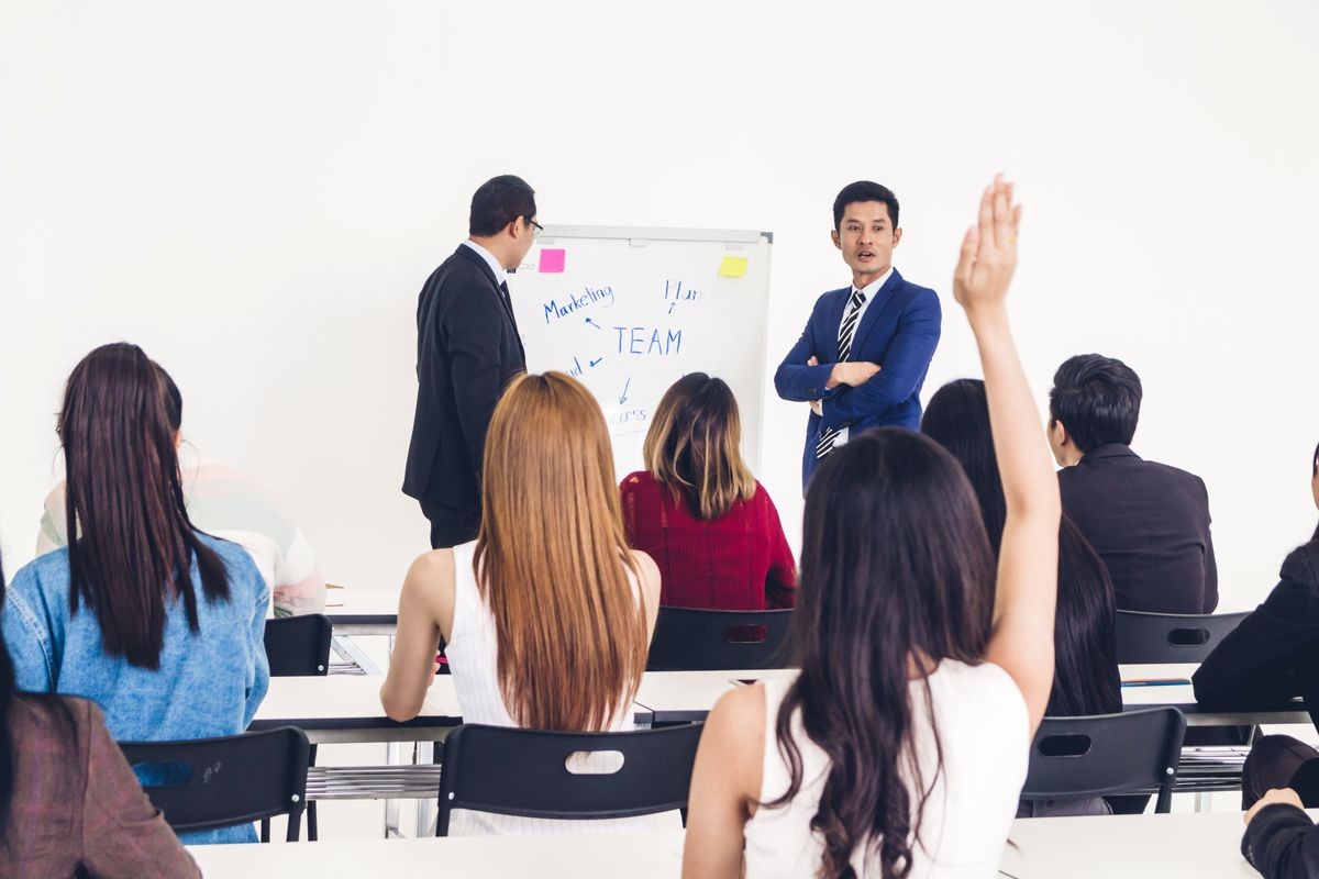 Businessman standing in front of group of people in consulting meeting conference seminar at hall or seminar room.presentation and coaching concept